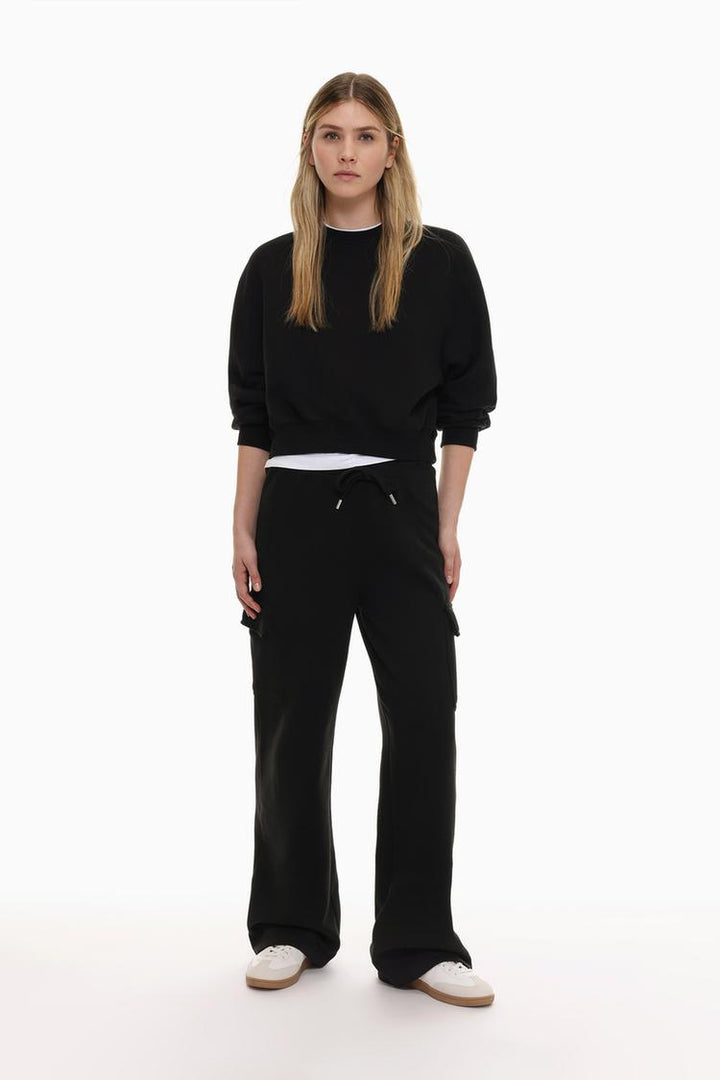 Zoomed-out view of a women's black basic cropped sweatshirt, showcasing the complete design, featuring the cropped length, relaxed fit, and simple, stylish silhouette.