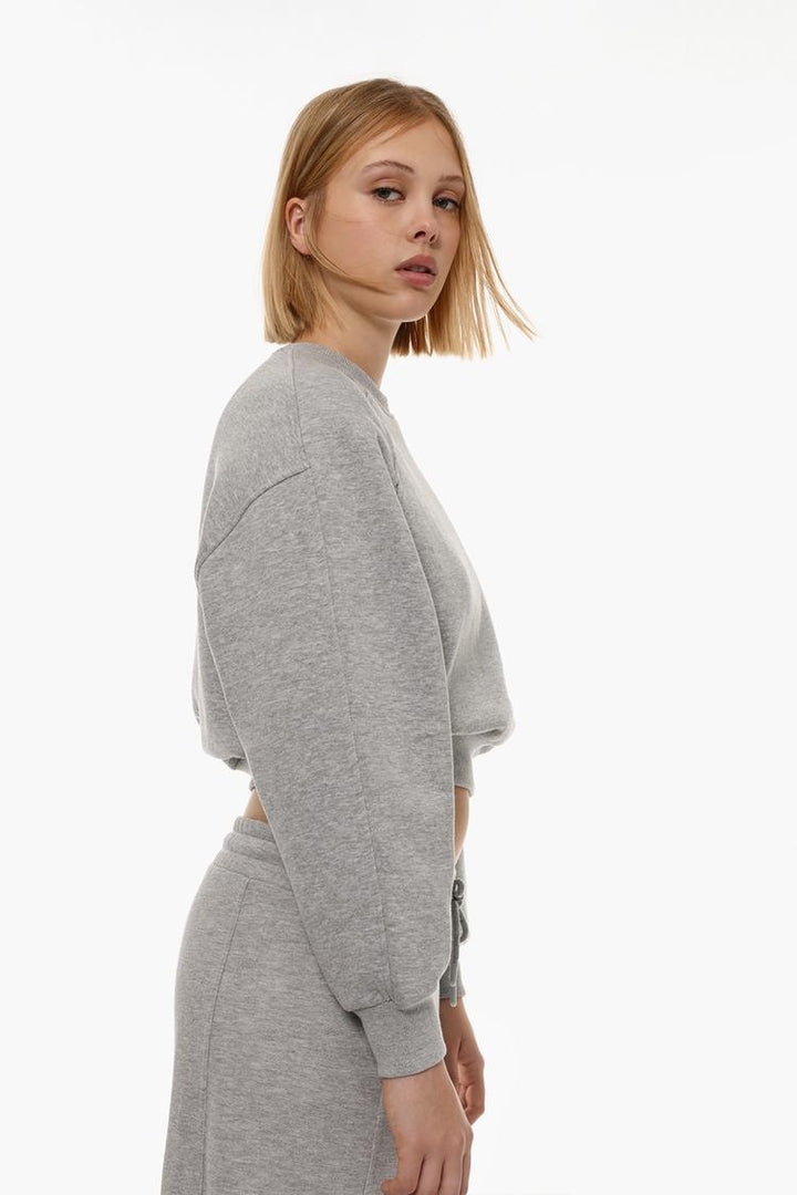 Full-body view of a women's grey basic cropped sweatshirt, showcasing the cropped length, relaxed fit, and minimalist design for a stylish casual look.