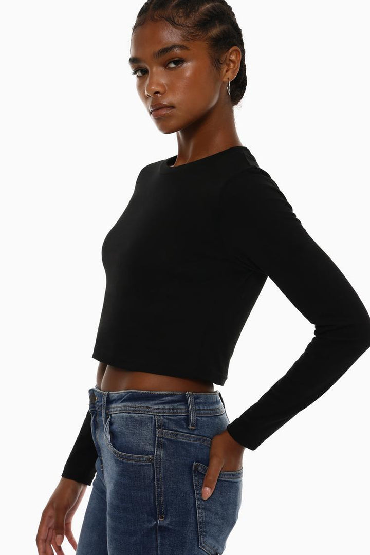 Side view of the black cropped long-sleeve top, emphasizing its tailored fit, long sleeves, and cropped length, offering a chic and minimalist profile.