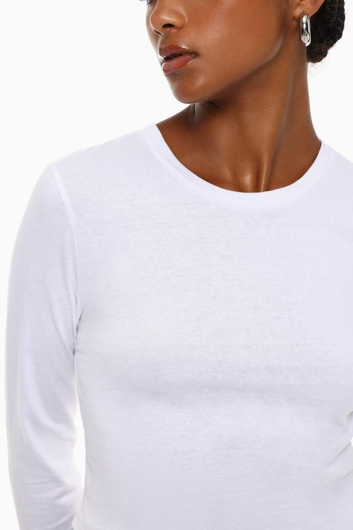 Body view of the white cropped long-sleeve top, highlighting its sleek design with long sleeves and a flattering cropped fit for a casual yet stylish look.