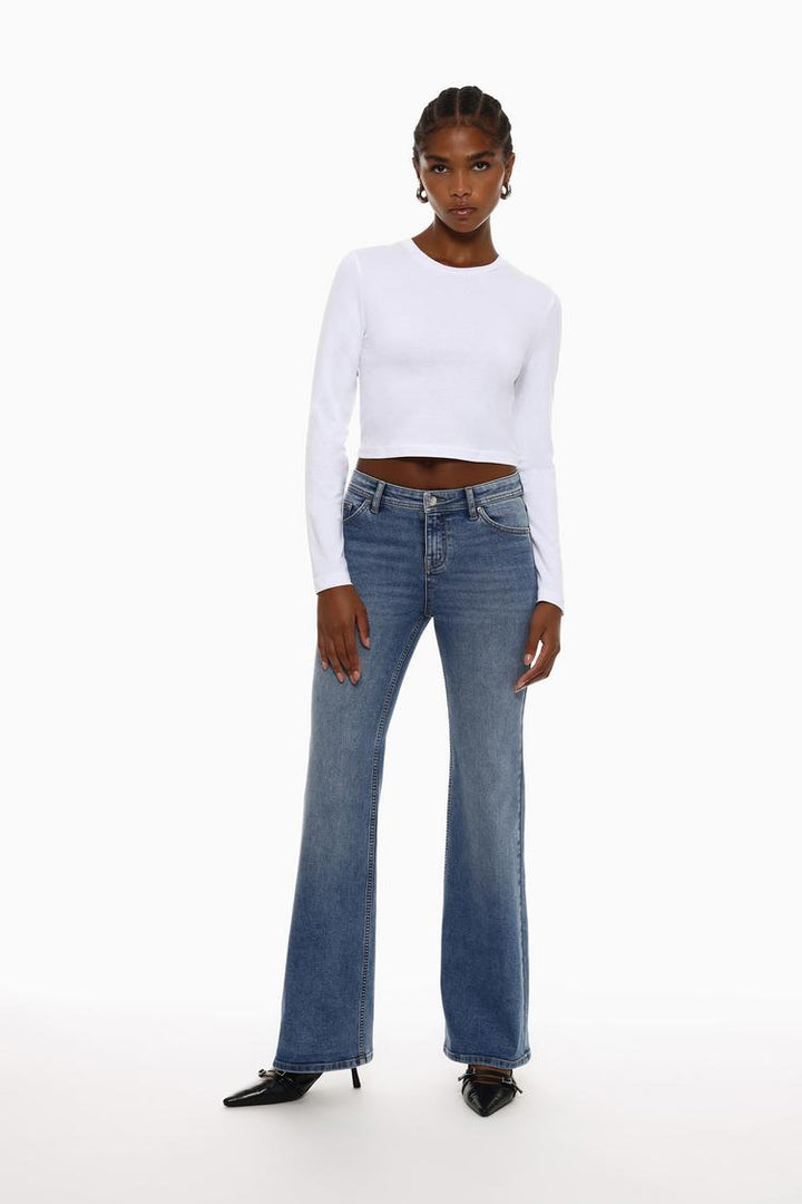 Full-body view of the white cropped long-sleeve top, highlighting its sleek design with long sleeves and a flattering cropped fit. Ideal for a casual yet chic outfit, offering a modern and stylish silhouette.