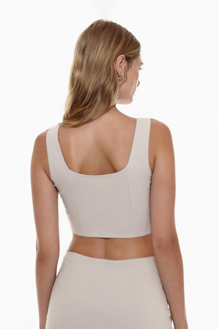 Back view of the beige rustic strappy top with a bow, highlighting the delicate straps and the charming bow detail, offering a chic and feminine look from every angle.