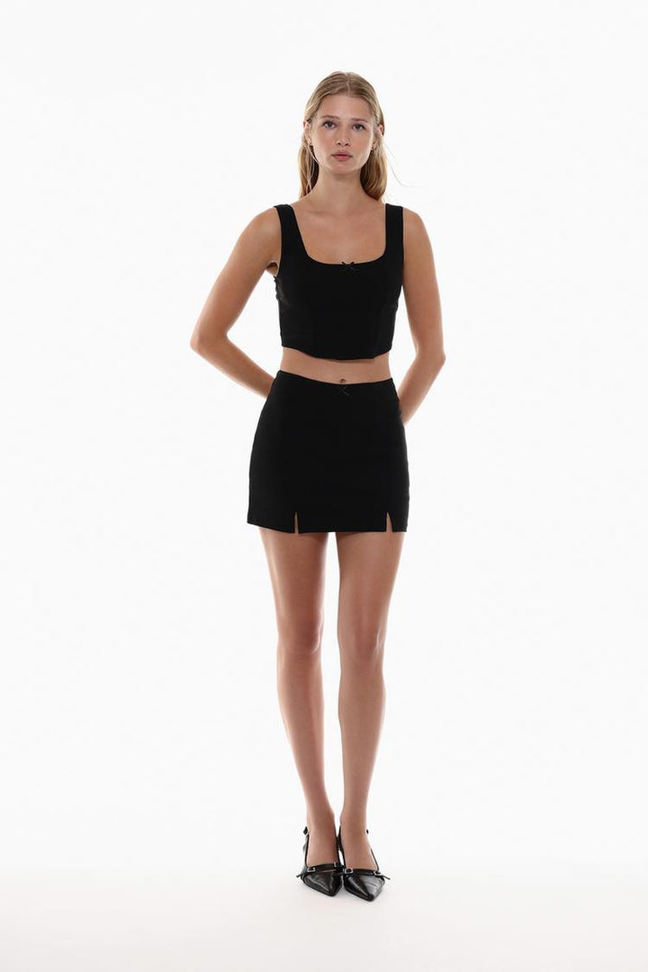 Full-body view of the black rustic strappy top with a bow, highlighting the delicate straps and charming bow detail for a chic, feminine look that flatters the figure.