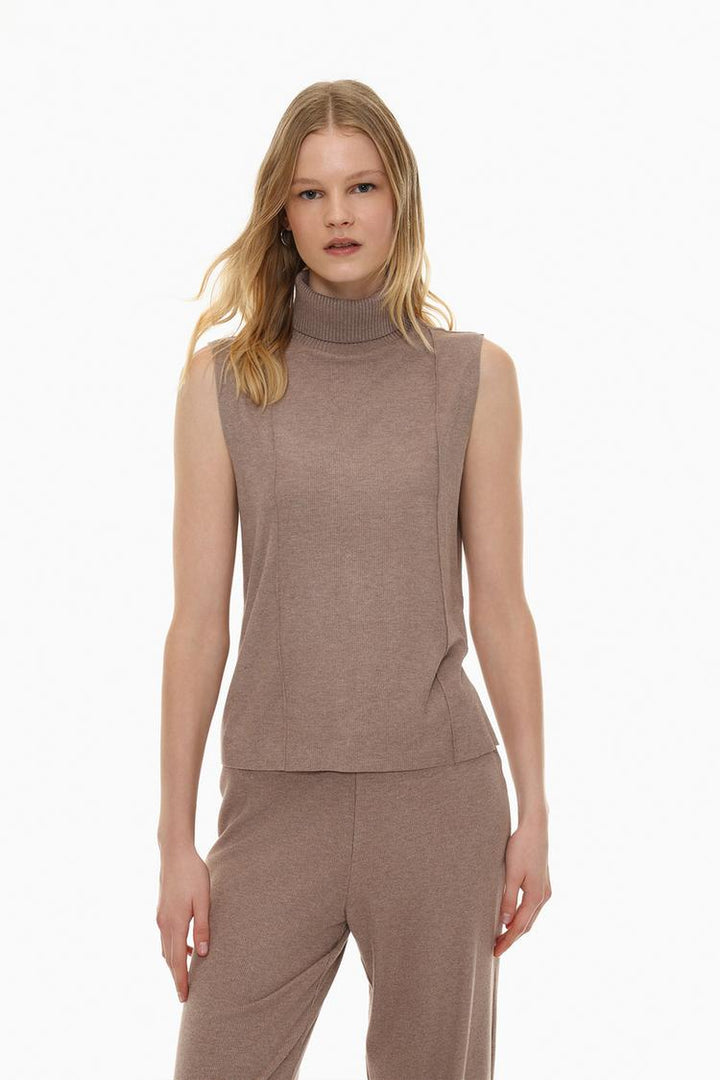 A beige soft-touch vest sweater, showcasing a lightweight, cozy design. The minimalist style and soft fabric provide a comfortable and versatile layering piece for any casual outfit.