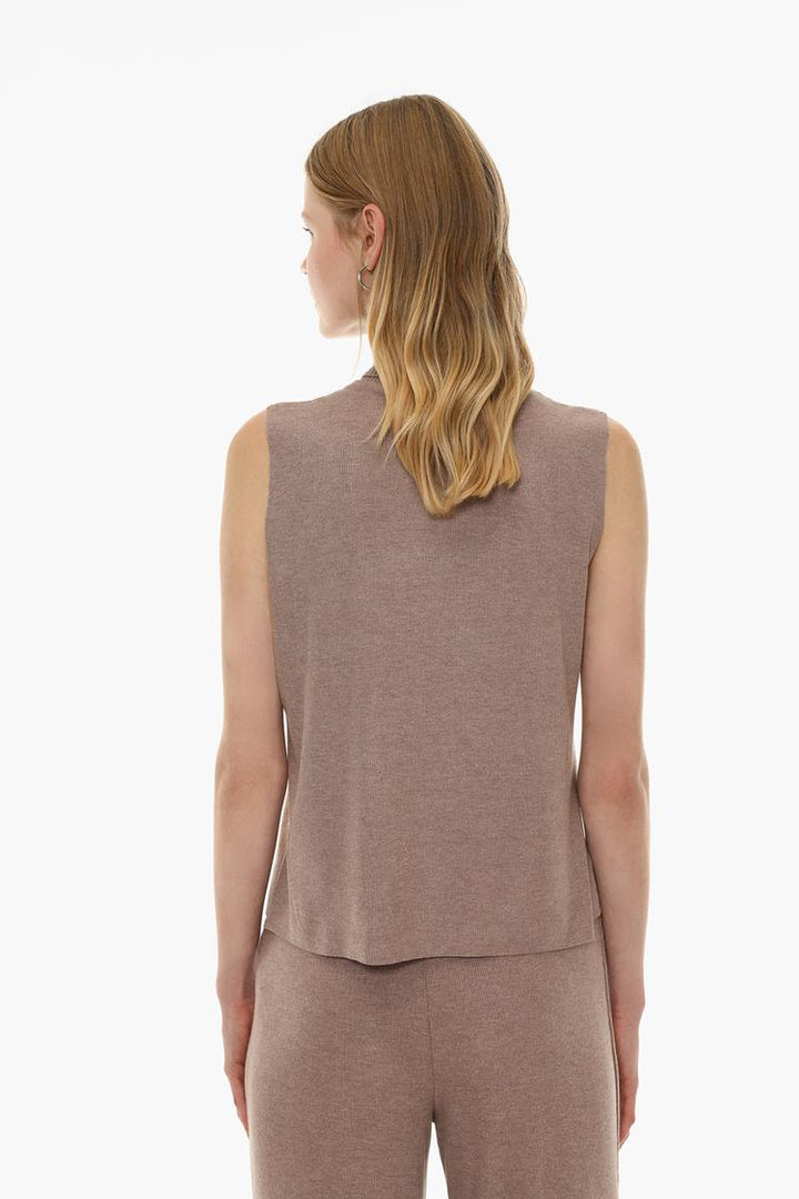 Back view of a beige soft-touch vest sweater, showcasing its simple and clean design, perfect for a casual, stylish look. The soft fabric and relaxed fit make it a comfortable choice for everyday wear.