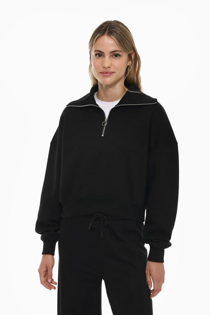 Women's black sweatshirt with a zip-up collar, designed for a sleek and comfortable look with adjustable warmth.