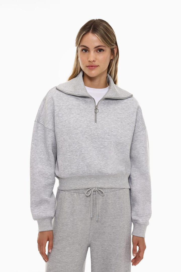 Women's grey sweatshirt with a zip-up collar, offering a comfortable and versatile style, perfect for layering and casual wear.