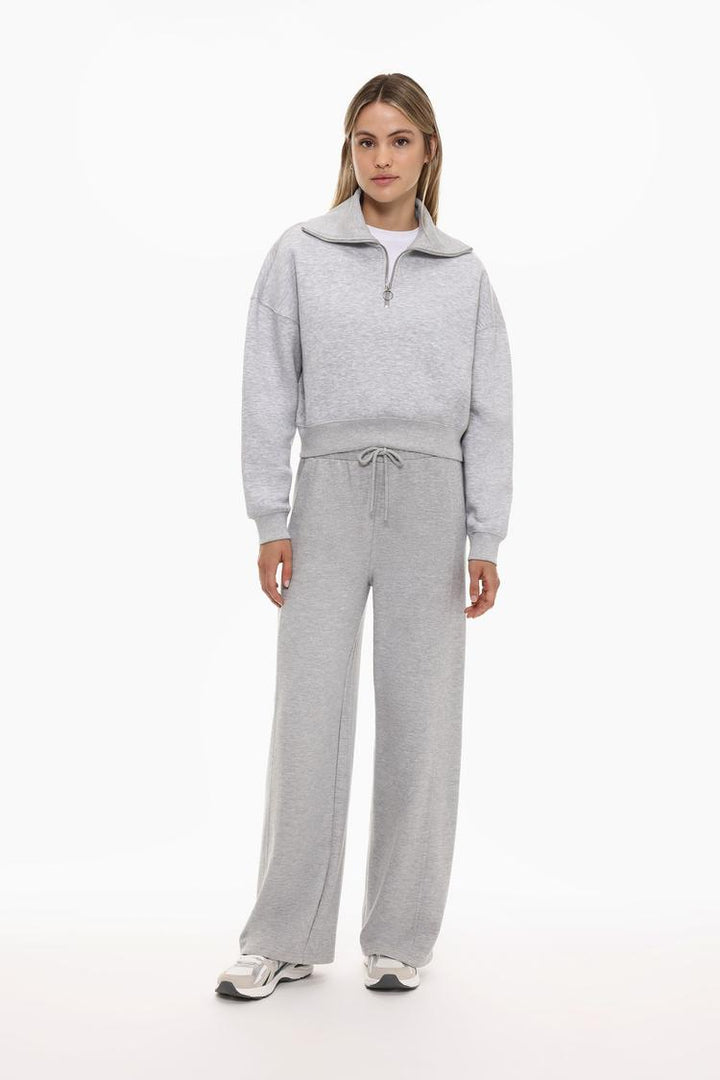 Full-body view of a women's grey sweatshirt with a zip-up collar, styled for a casual and comfortable look.