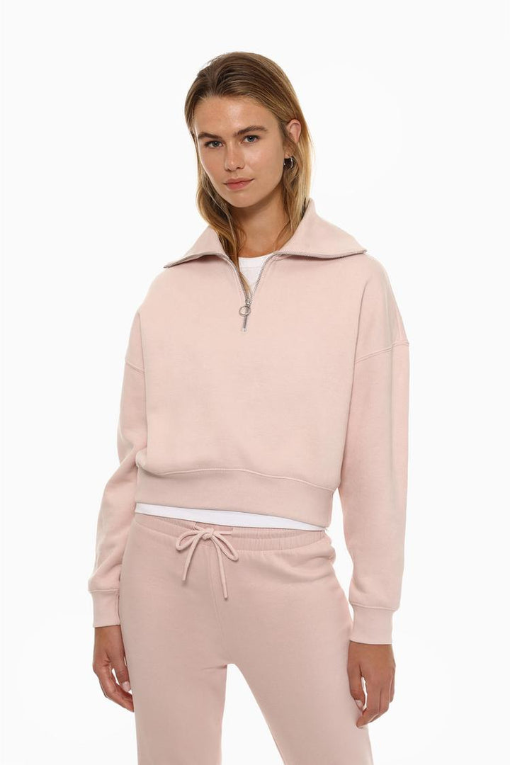 Women's pink sweatshirt featuring a zip-up collar, designed for a comfortable and stylish look with adjustable warmth.