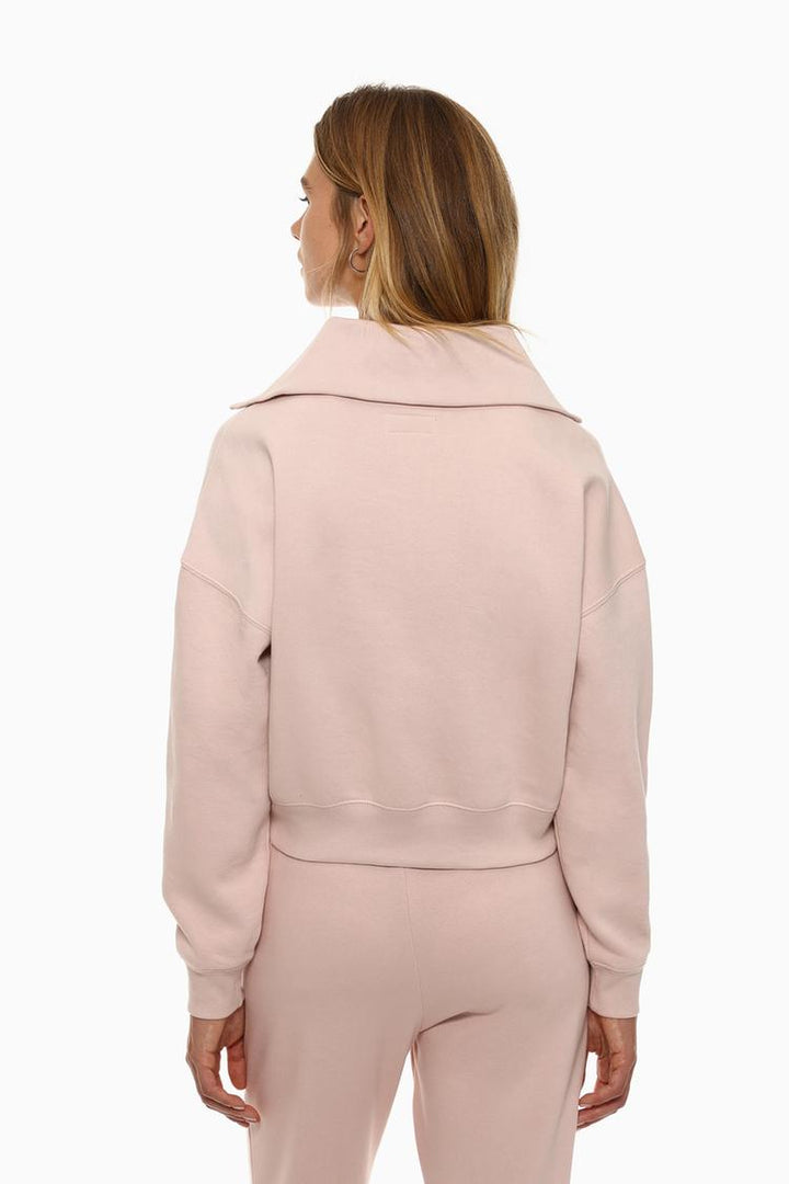 Back view of a women's pink sweatshirt with a zip-up collar, featuring a simple, clean design and a comfortable fit.