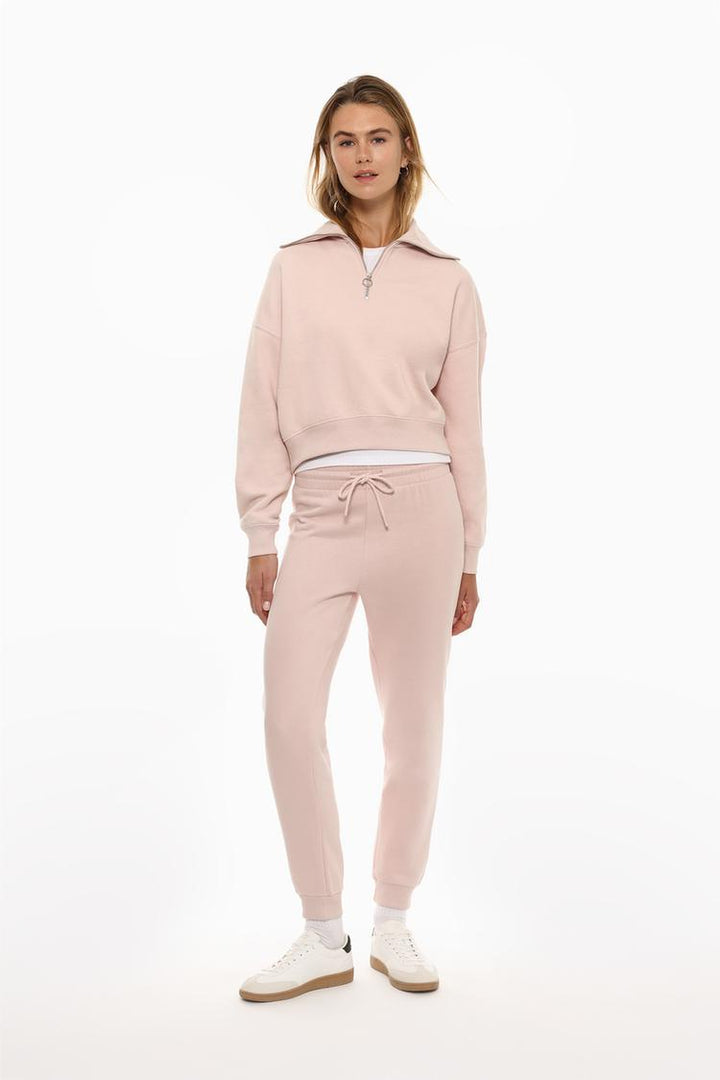 Full-body view of a women's pink sweatshirt with a zip-up collar, styled for a casual and comfortable look.