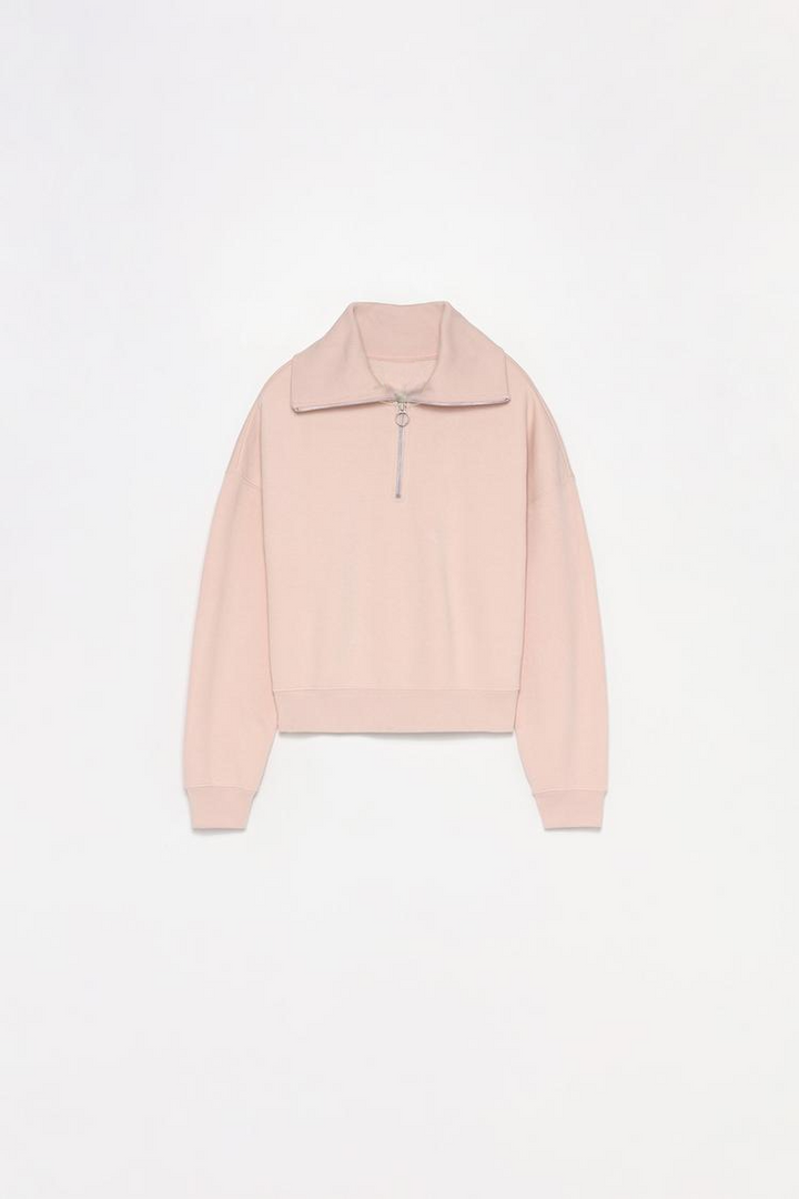 Women's pink sweatshirt with a zip-up collar, offering a versatile and cozy style perfect for layering and casual wear.