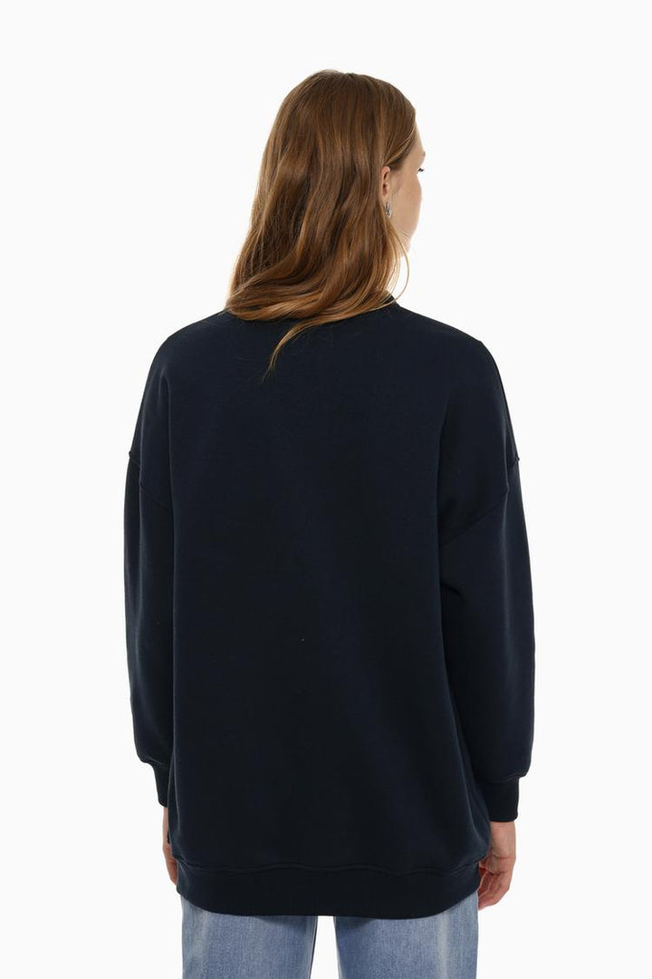 Back view of a women's navy blue oversized sweatshirt featuring an asymmetric design and a relaxed fit.