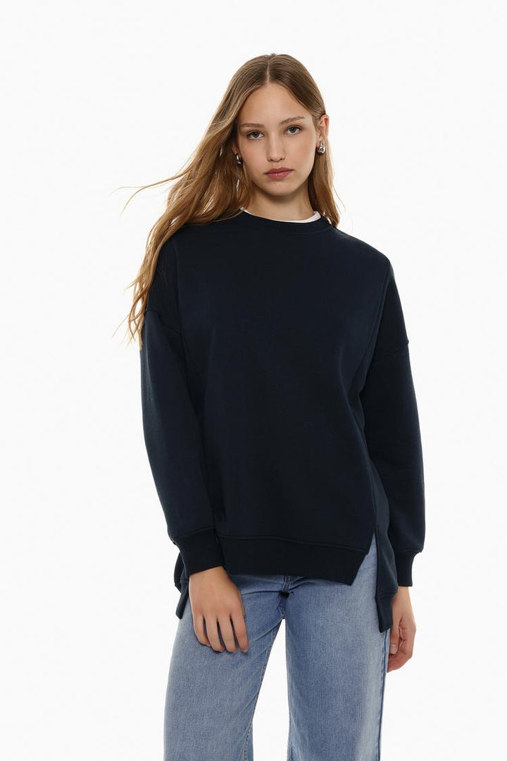 Zoomed-in view of the body section of a women's navy blue oversized sweatshirt, highlighting the asymmetric design and fabric details.