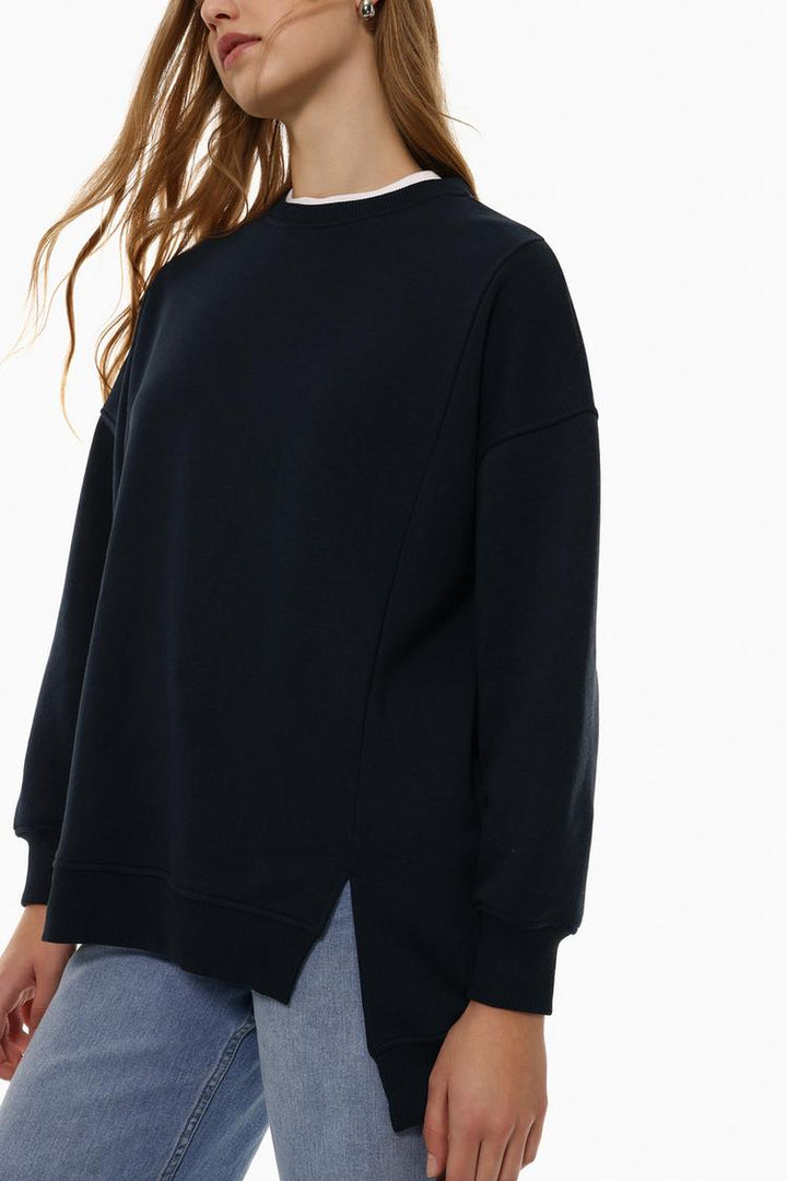 Side view of a women's navy blue oversized sweatshirt showcasing the asymmetric design and relaxed fit.