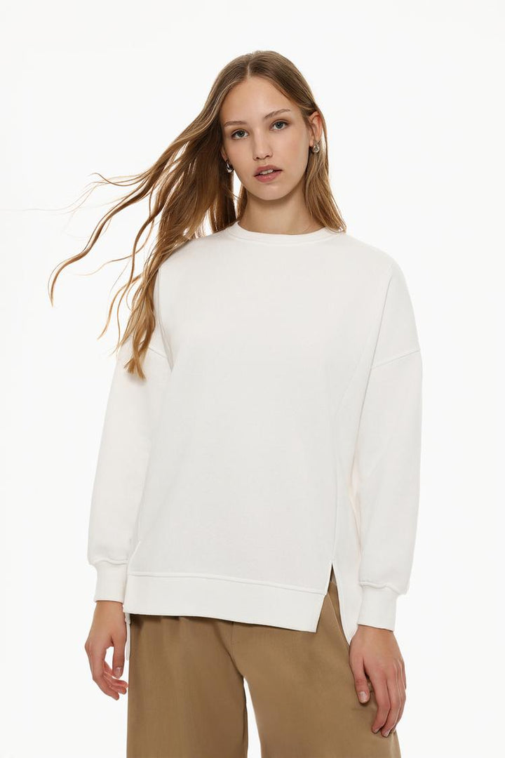 Women's white oversized sweatshirt with an asymmetric design, offering a modern and comfortable style.