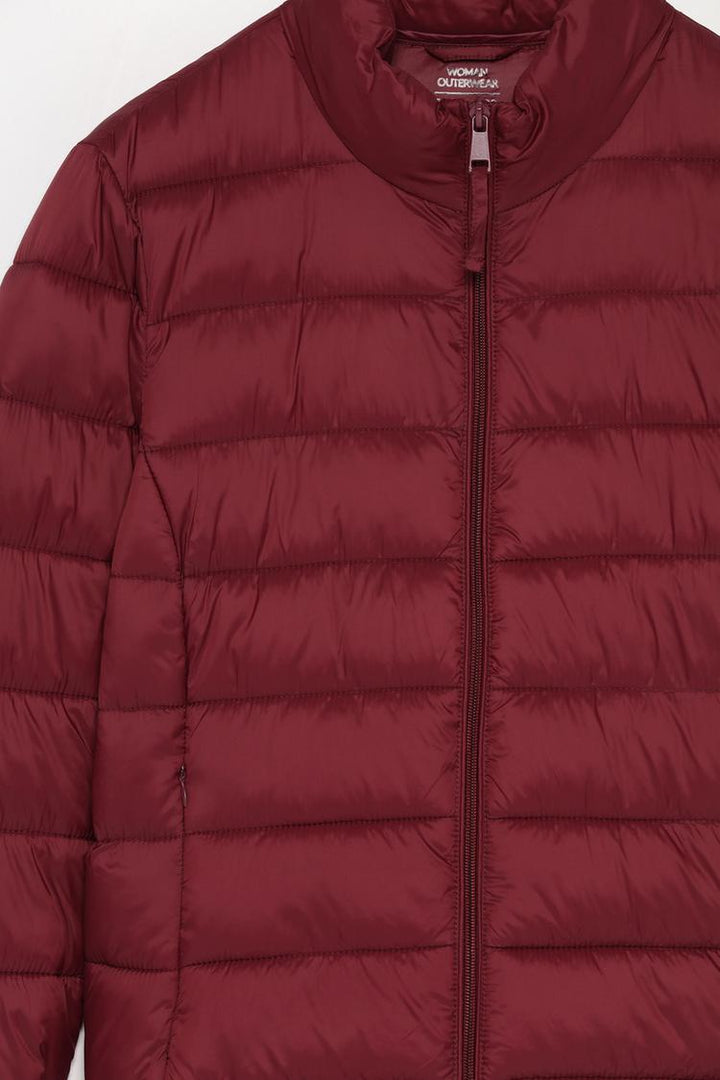 Close-up of a basic lightweight puffer jacket in vibrant red, highlighting the detailed stitching and premium fabric quality.