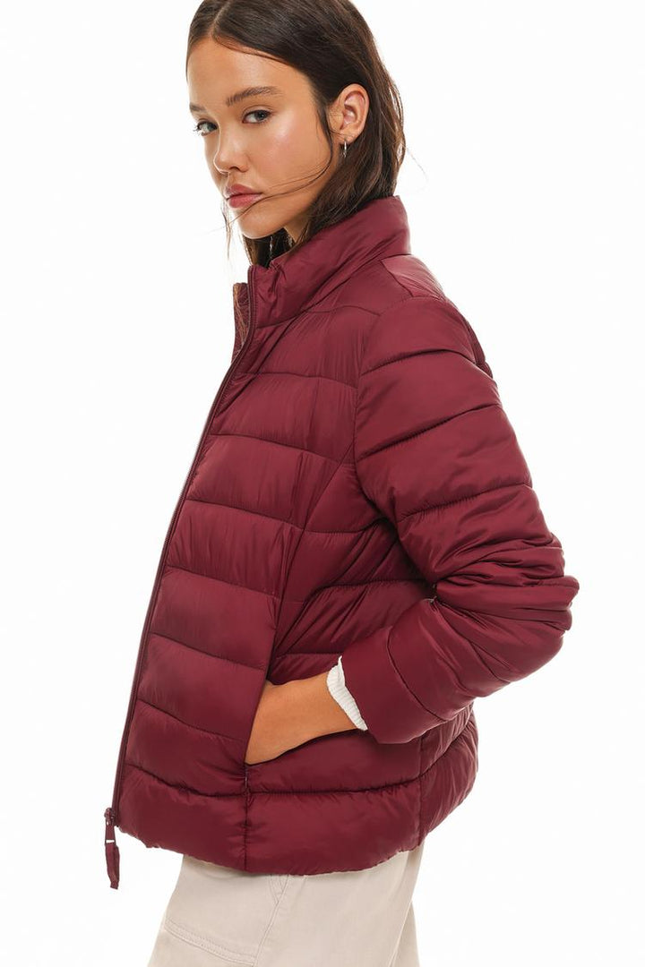 Side view of a basic lightweight puffer jacket in vibrant red, showcasing its slim profile and stylish fit.