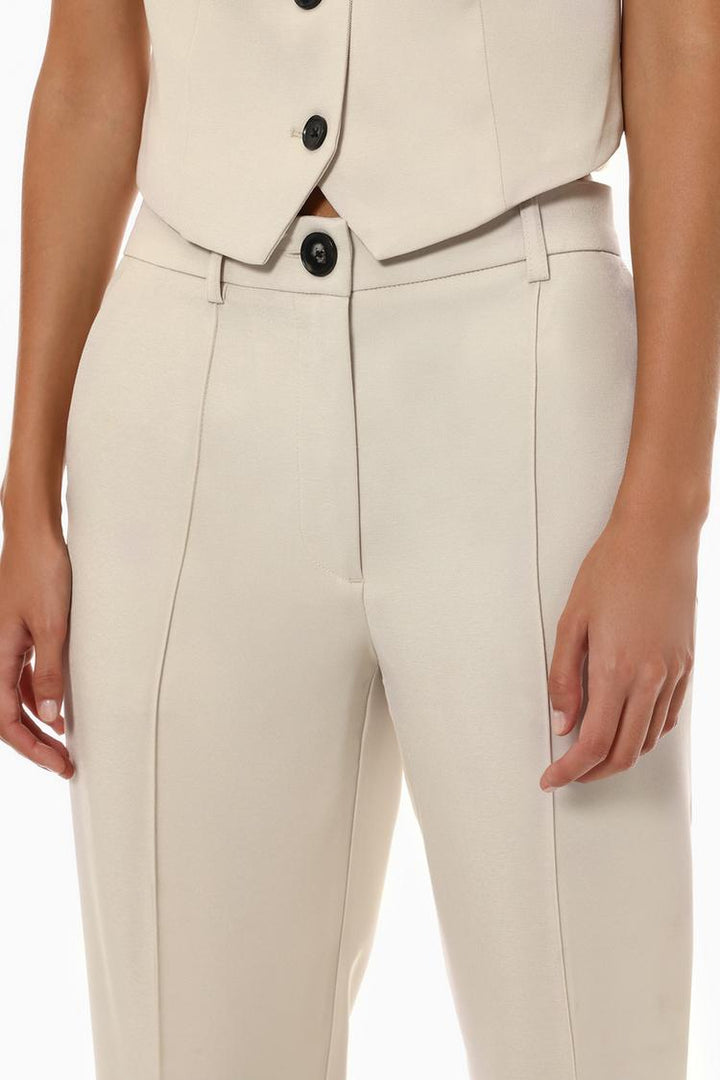 Beige basic smart trousers, body display focusing on their relaxed yet refined style