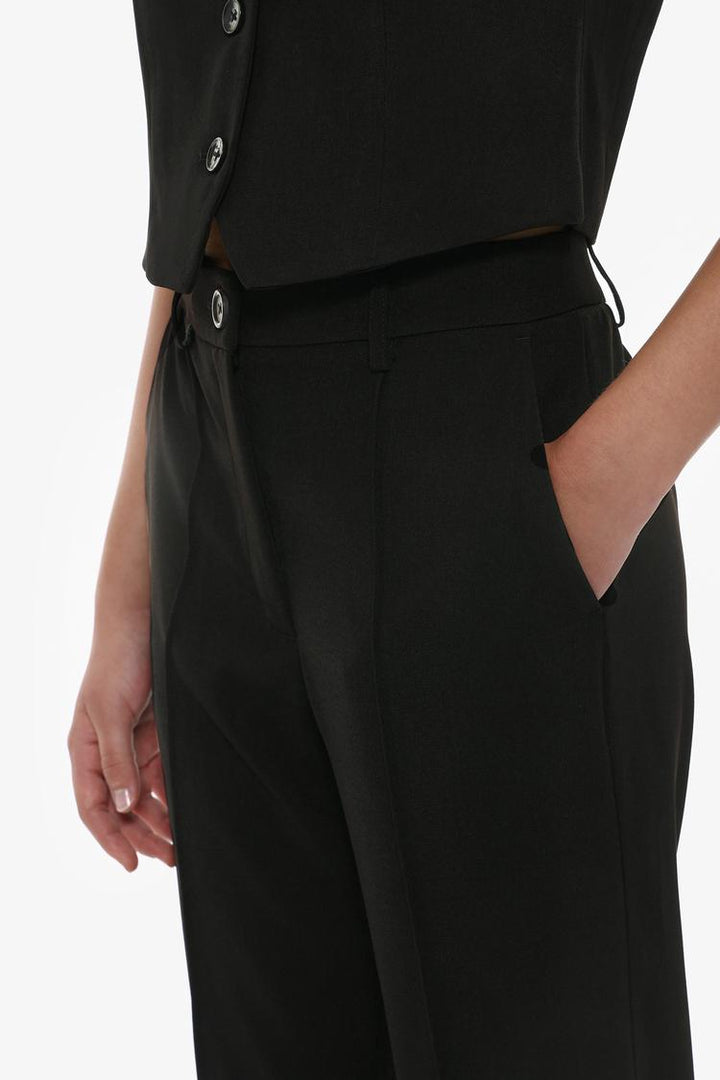 Full-body view of black basic smart trousers styled with a formal outfit for inspiration