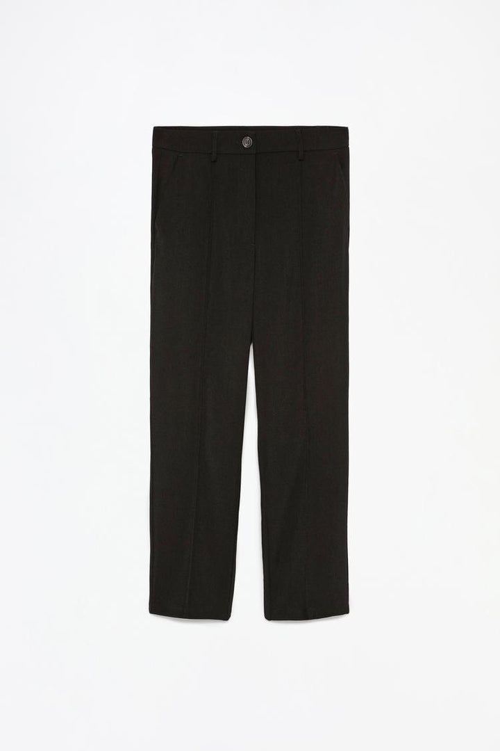 Side view of black basic smart trousers, highlighting sharp crease lines and premium material