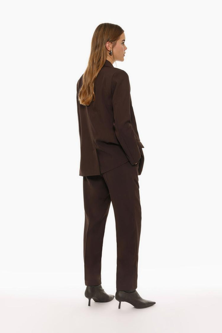 Full-body view of brown basic smart trousers paired with complementary attire