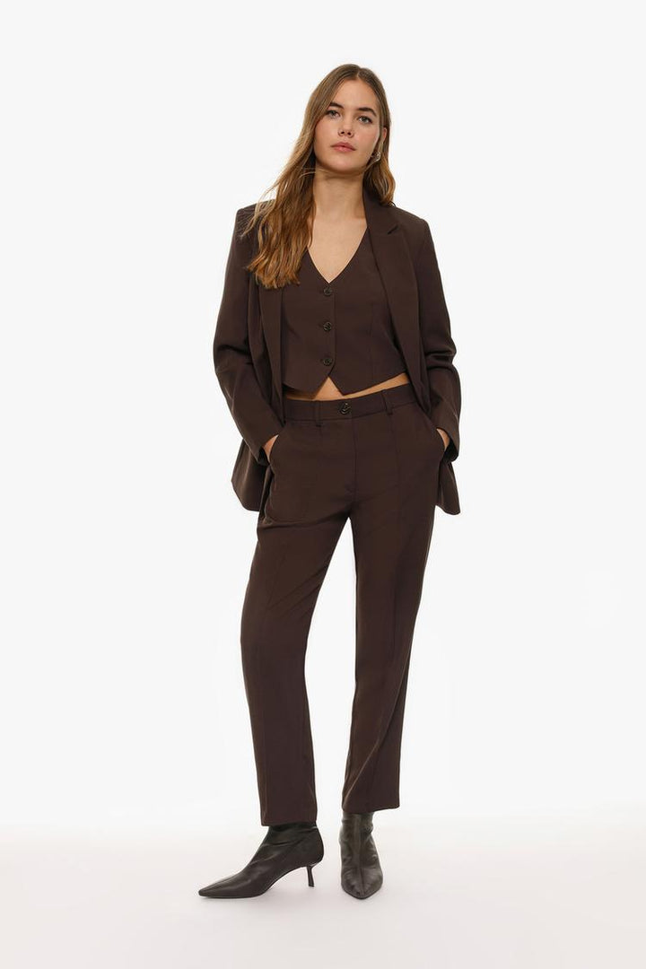 Full-body view of brown basic smart trousers paired with complementary attire
