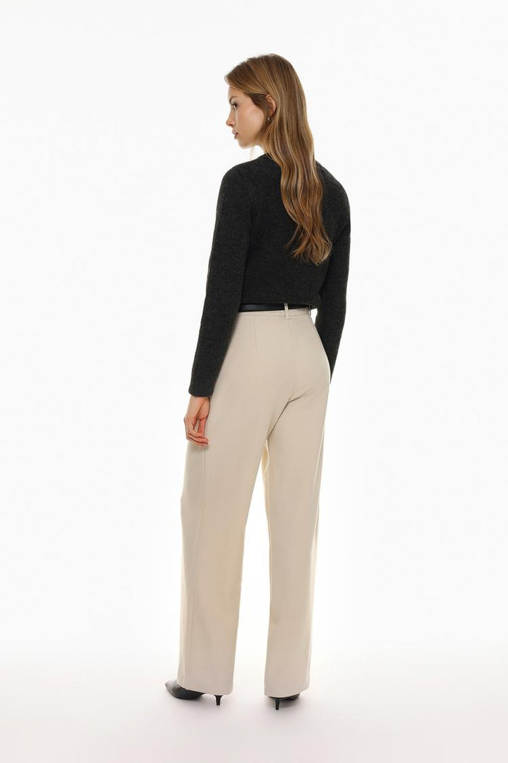 Back view of beige belted wide-leg trousers, showcasing seamless tailoring
