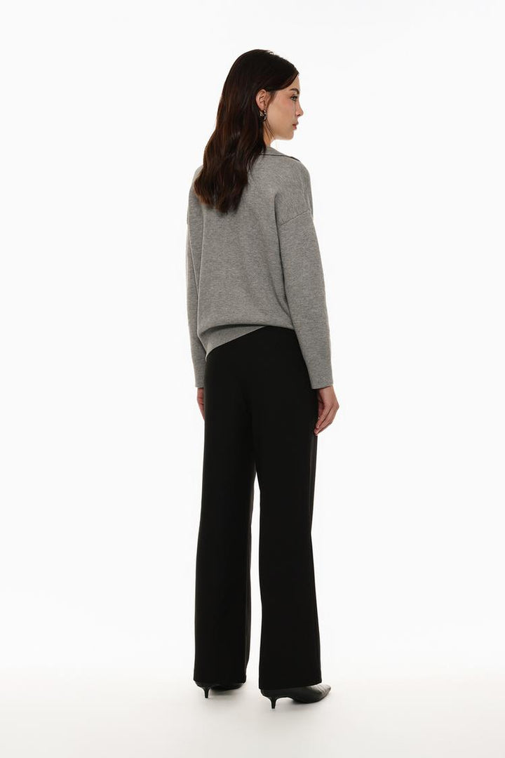 Rear view of black belted wide-leg trousers, emphasizing precision tailoring