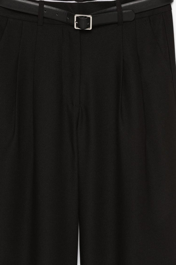 Product close-up of black belted wide-leg trousers, highlighting the sophisticated details