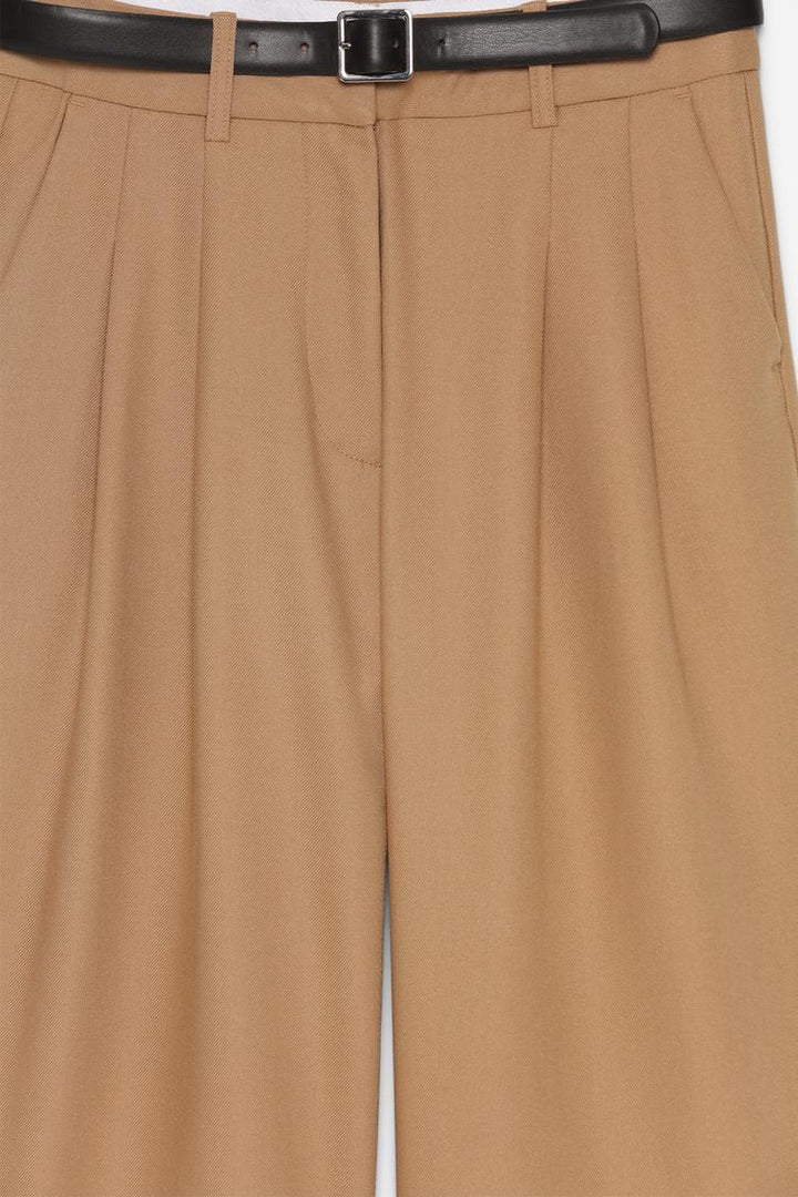 Product close-up of bronze belted wide-leg trousers, emphasizing premium quality and vibrant color