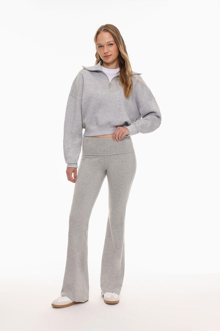 Full-body shot emphasizing the grey leggings' flattering fit and fold-over waist detail.