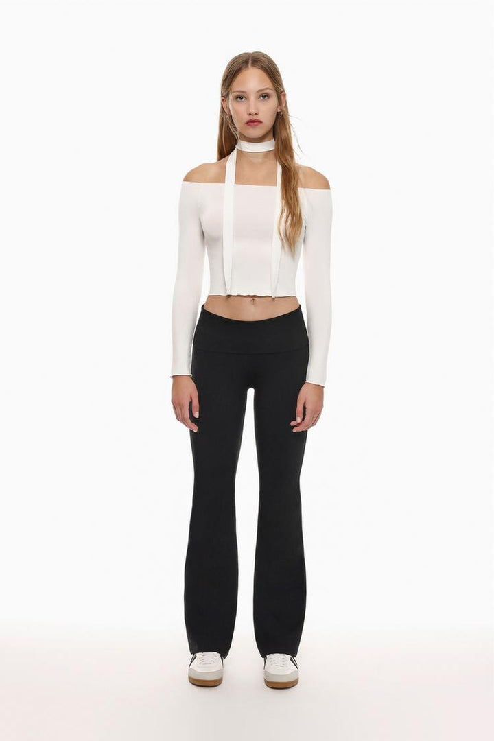 Full-body shot highlighting the fold-over waist detail and the flattering fit of the black leggings.