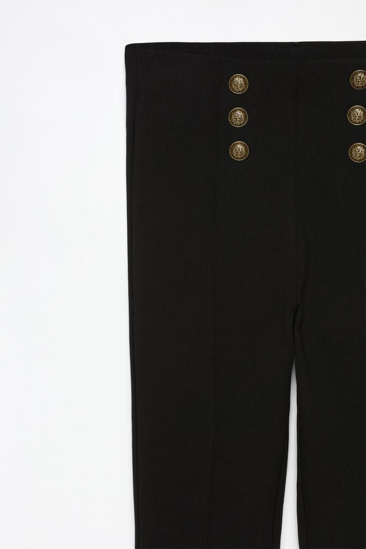 Close-up view of the black leggings, highlighting the premium stretch fabric and polished buttons.