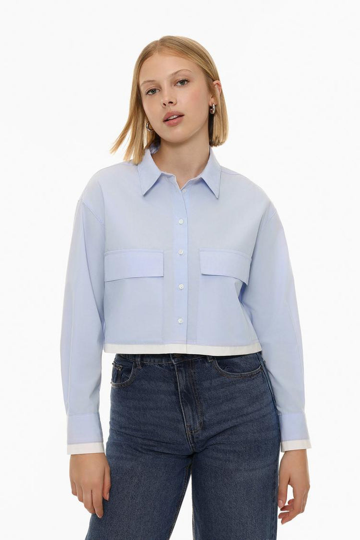 A contrast cropped shirt, featuring a unique design with contrasting colors or fabric textures. This shirt offers a modern, bold look with a cropped cut that pairs well with high-waisted bottoms. Perfect for creating stylish outfits with a touch of edge, it can be dressed up or down for various occasions.