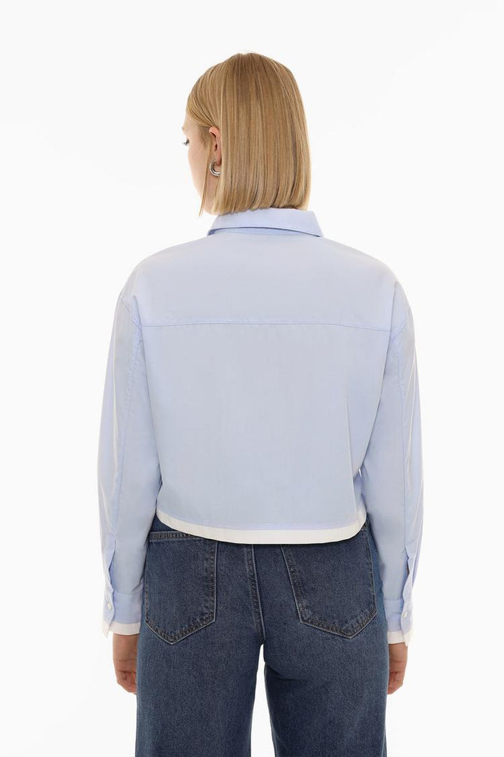 A contrast cropped shirt back, showcasing the unique design elements from the rear view. The back may feature contrasting colors, materials, or design details that complement the front, adding a fashionable and eye-catching touch to the overall look.