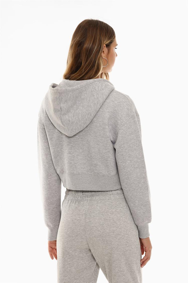 Back view of a women's grey cropped jacket, showcasing its clean design, cropped length, and relaxed fit.