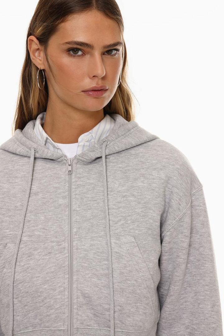 Zoomed-in view of a women's grey cropped jacket, highlighting the fabric texture, stitching details, and contemporary design.