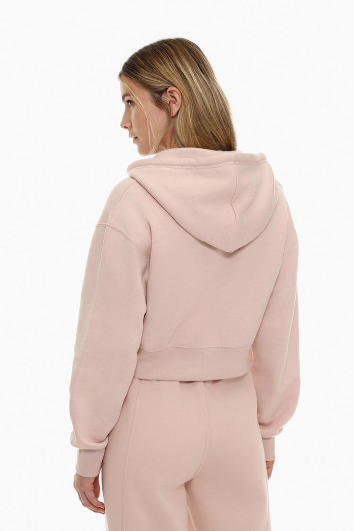 Back view of a women's pink cropped jacket, showcasing the clean, modern design with a cropped length and relaxed fit.