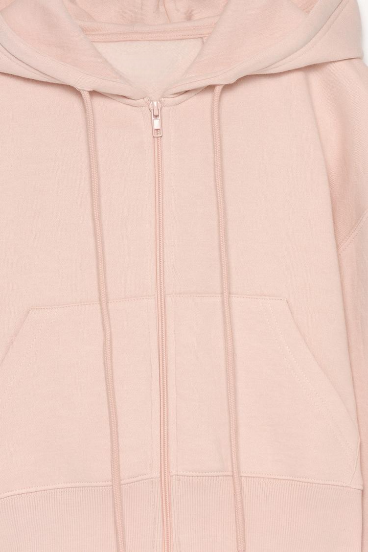 Zoomed-in view of a women's pink cropped jacket, showcasing the fabric texture, stitching details, and stylish cropped design.