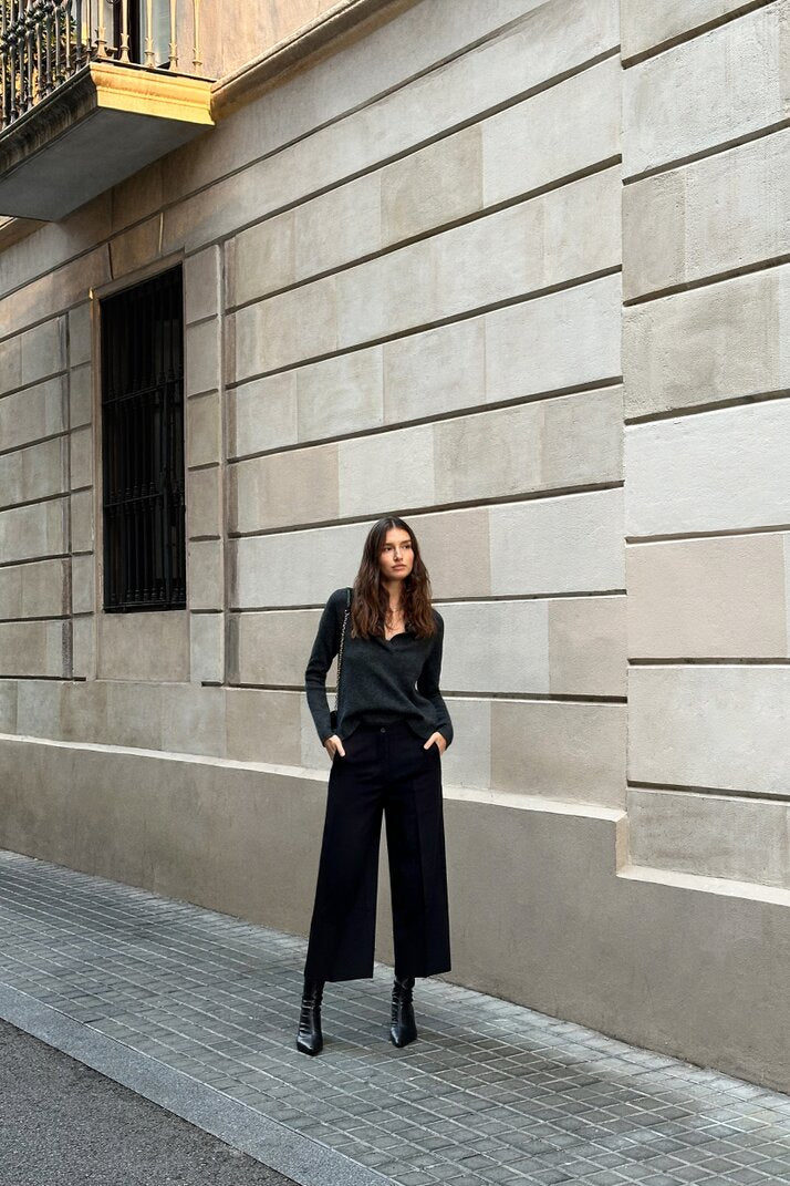 Black culottes modeled with a side angle to highlight their elegant drape