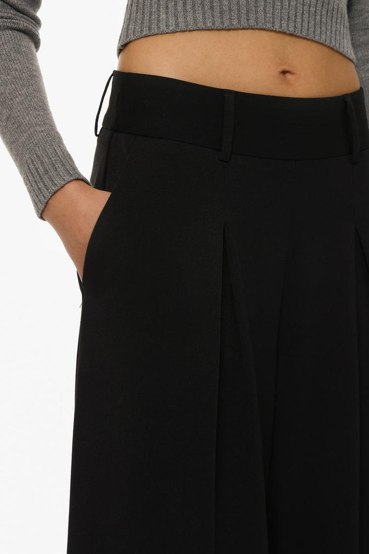 Zoomed-in image of black culottes, focusing on the fine fabric texture and craftsmanship