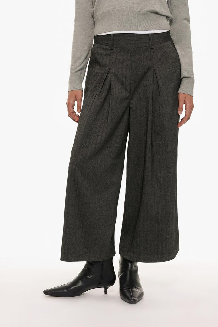 Grey culottes modeled to highlight their tailored fit and high-waist design