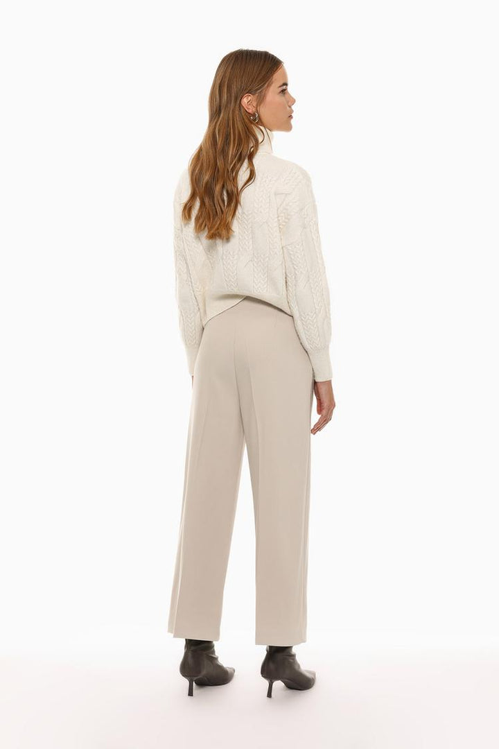 Back view of beige culottes without a waistband, highlighting their seamless and flowy structure.