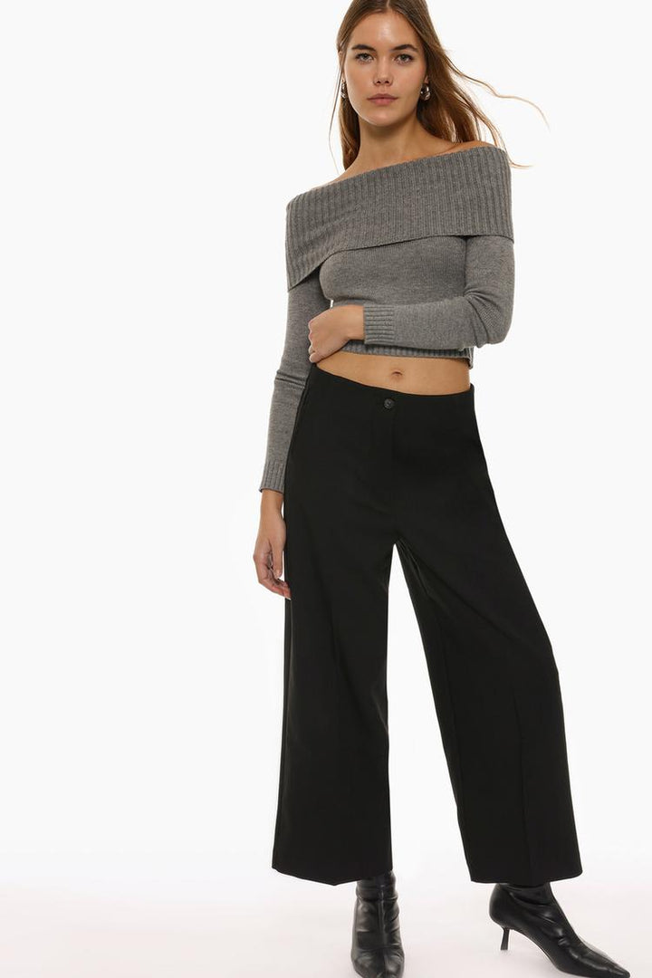 Full-length view of black culottes styled with a casual top, presenting a modern and relaxed ensemble.