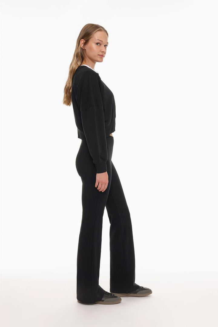 Zoomed-in shot focusing on the ribbed waistband and the soft fabric texture of the black leggings.