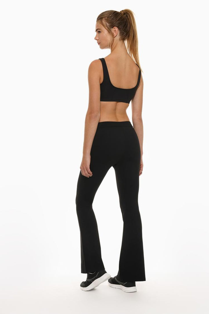 Back view of the black flared leggings, highlighting the fit and flared hem design.