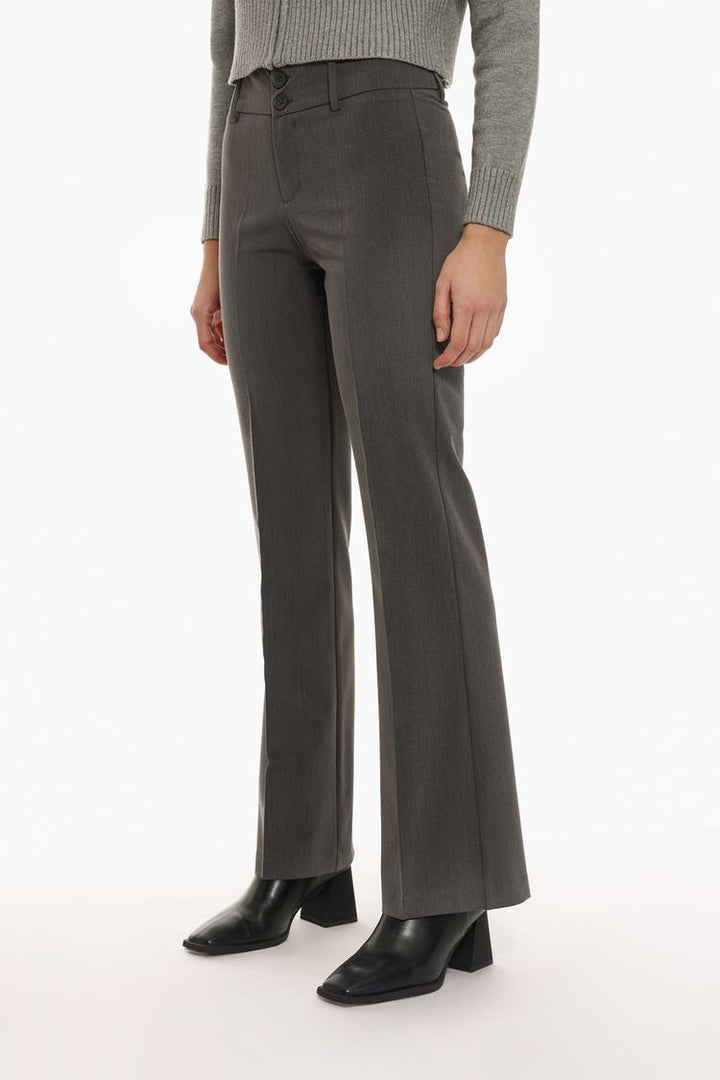 Close-up of grey flared trousers, focusing on fabric texture and craftsmanship