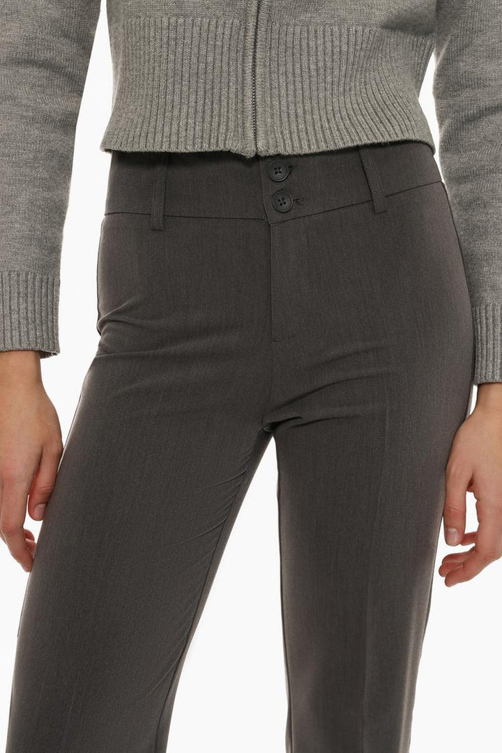 Full-body view of grey flared trousers, styled with complementary outfit pieces