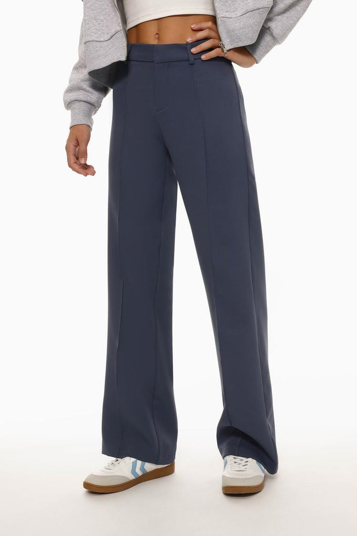 Front view of the blue flared trousers with pleats, focusing on the front pleating details and the flattering fit around the waist and hips.